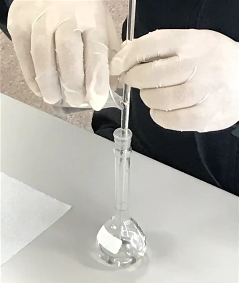 Fig. 3 Preparation of 0.1 mol/L TBAP/ACN solution. Transfer the solution from the beaker to a 50 mL volumetric flask using a glass rod or similar to prevent spillage. Using a 1 mL pipette adjust the volume of the volumetric flask to 50 mL while adding ACN solution to prepare a 0.1 mol/L TBAP/ACN solution.